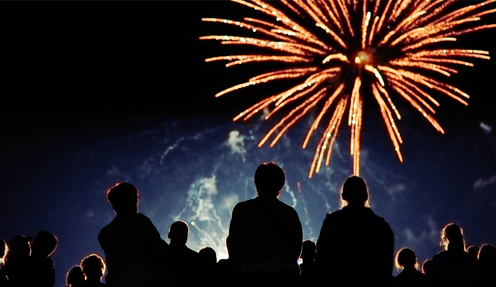 Crowd watches vibrant fireworks burst in the night sky, ideal for Southport rentals celebrations and events.