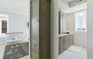 Bright room with modern wooden cabinets, a small kitchenette, and a window with a curtain. Ideal for Southport rentals.
