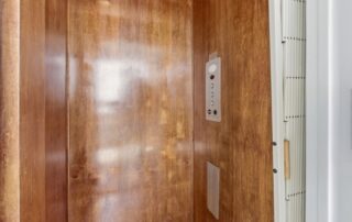 Wood-paneled elevator with control buttons, suitable for Southport rentals.
